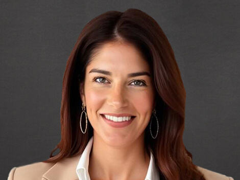 Trulie Nielsen smiles at the camera wearing a tan blazer.