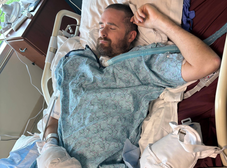 Brian laying in a hospital bed.