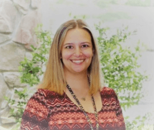 Kaitlyn Ners Senior Clinical Liaison for Kessler Institute for Rehabilitation smiles at the camera in front a tree.