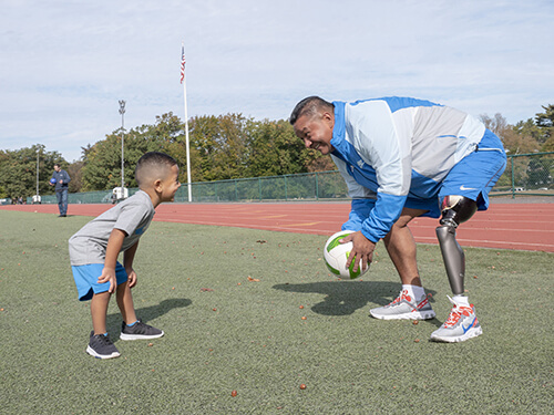 Weimar, an amputee, is playing soccer with his son