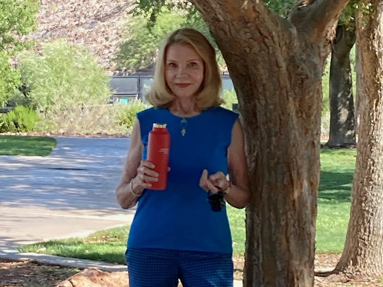 Carol Campbell stands outside next to a tree.
